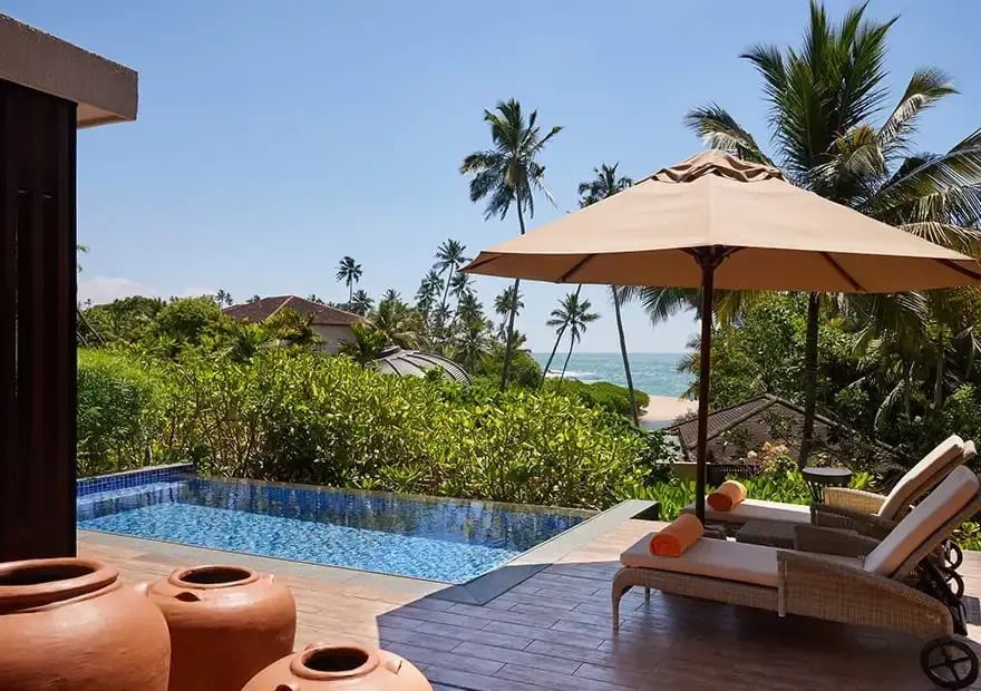 Privater Pool mit Meerblick und Lounge-Bereich bei Sonnenschein