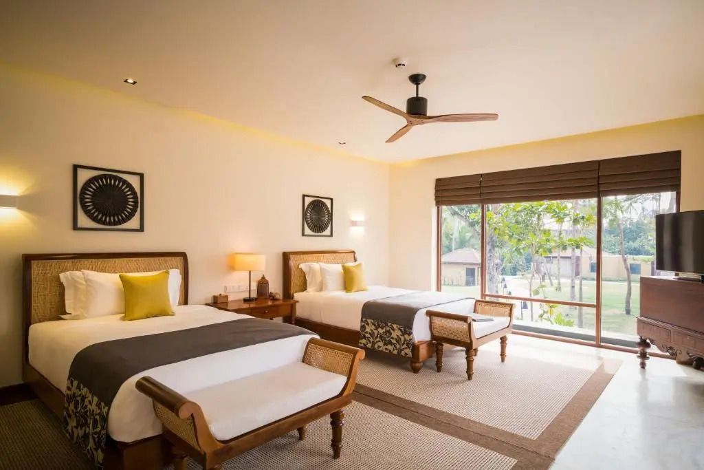 Zweites Schlafzimmer der Villa mit zwei Einzelbetten und großen Fenstern.