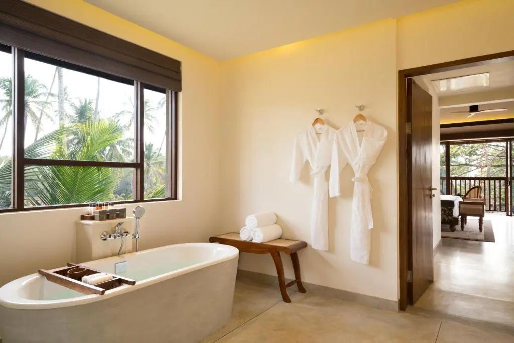 Geräumiges Badezimmer mit freistehender Badewanne und Bademänteln.