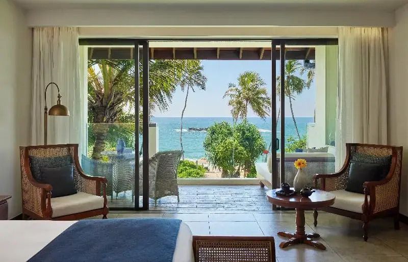 Offenes Zimmer mit Terrasse und Blick auf das tropische Meer