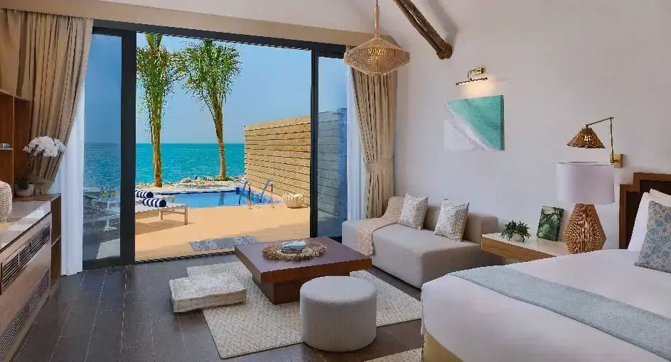 Helles Schlafzimmer mit Blick auf den Pool und das Meer