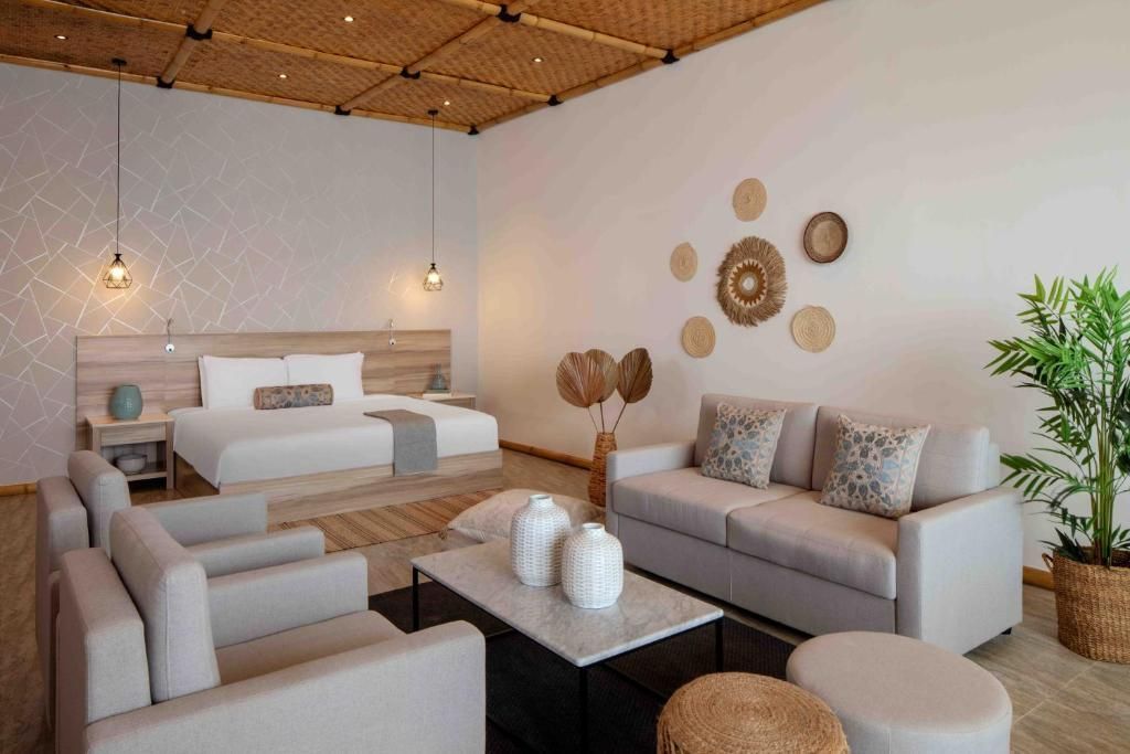 Moderne Suite mit Doppelbett, gemütlicher Sitzecke und stilvoller Dekoration.