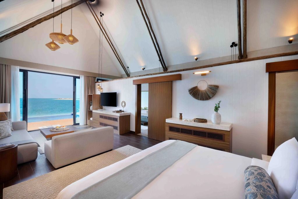 Elegantes Schlafzimmer mit offenen Holzbalken und Meerblick