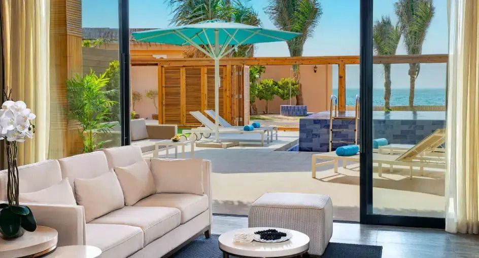Blick vom Wohnbereich auf Terrasse mit Pool und Meerblick