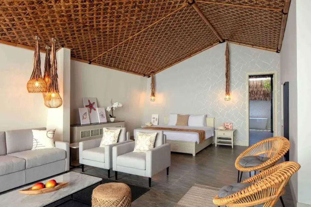 Elegante Junior-Suite mit Doppelbett und moderner Einrichtung. Gewebte Decke mit hängenden Lampen.