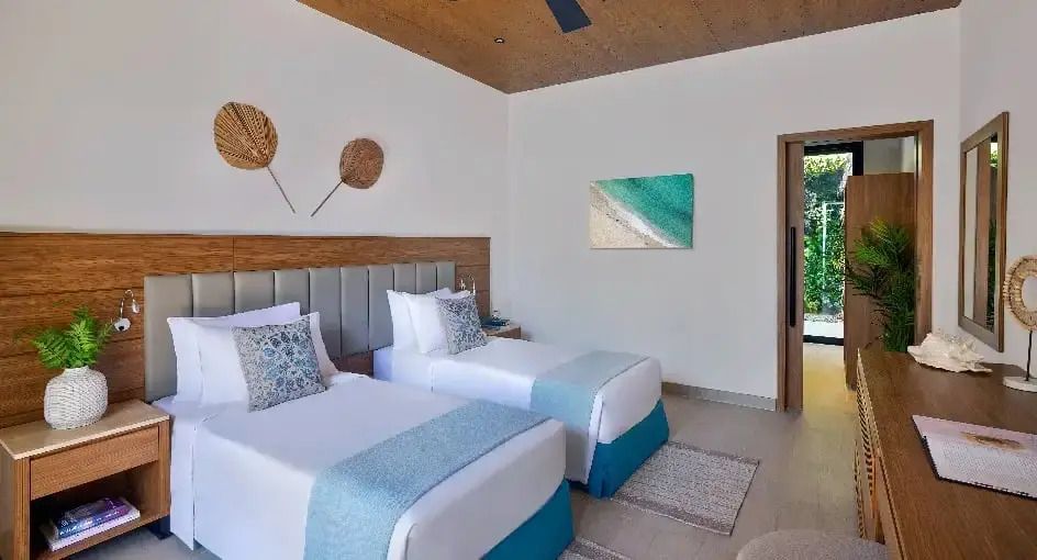 Zweibettzimmer mit stilvollen Dekorationen und Kunst an den Wänden.