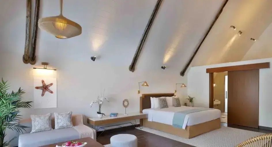 Geräumiges Zimmer mit Doppelbett und gemütlichem Sitzbereich, hell und einladend