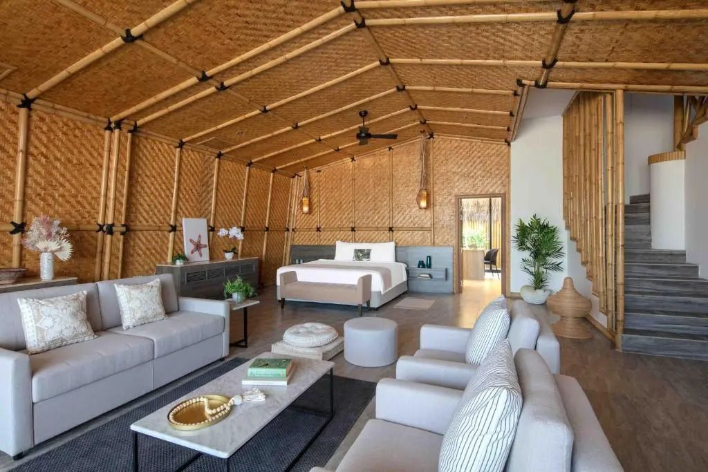 Geräumiger Wohnbereich einer Pool Villa mit stilvollen Möbeln und Holzdekor