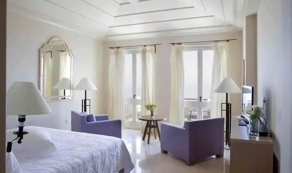 Helles Schlafzimmer mit eleganten Möbeln und Meerblick