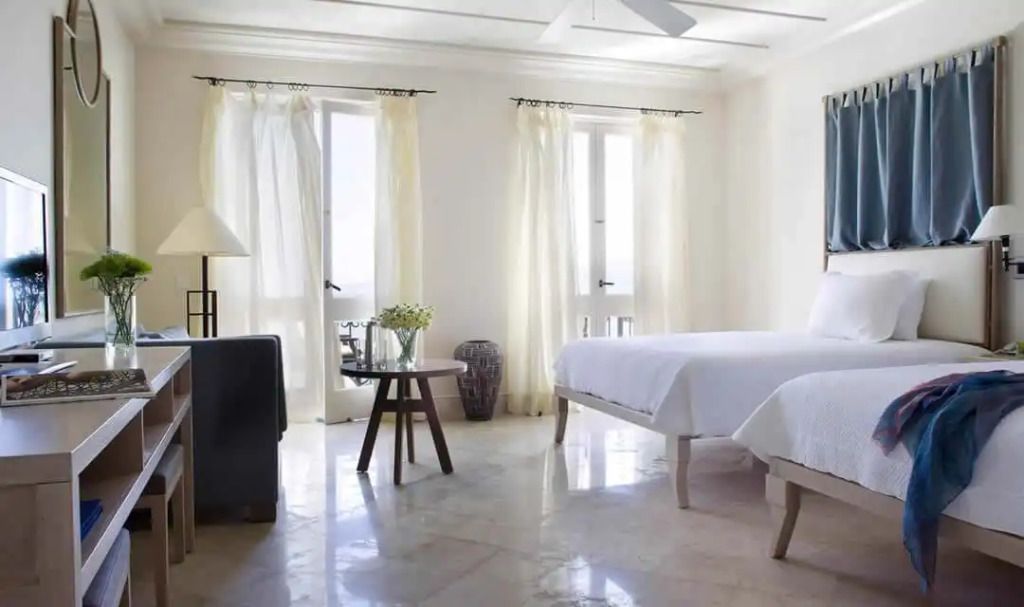 Schlafzimmer mit Doppelbetten, natürlichem Licht und entspannter Atmosphäre