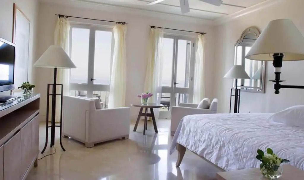 Helles Schlafzimmer mit Sitzbereich und Panoramablick im Alcyone Residence