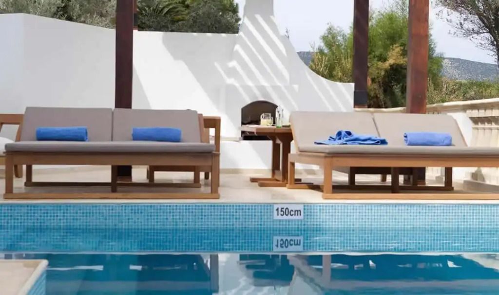 Außenbereich mit Pool und gemütlichen Liegen im Alcyone Residence