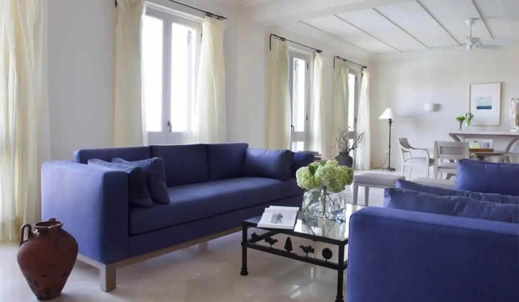 Moderne Lounge mit blauen Sofas und natürlichem Licht im Alcyone Residence