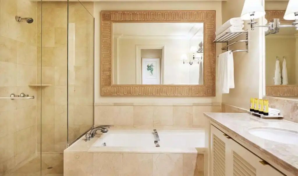 Elegantes Badezimmer mit großer Badewanne und stilvollem Spiegel im Alcyone Residence
