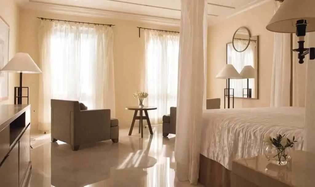 Helles Schlafzimmer mit Baldachinbett und Sitzbereich in der Alexandros Residence