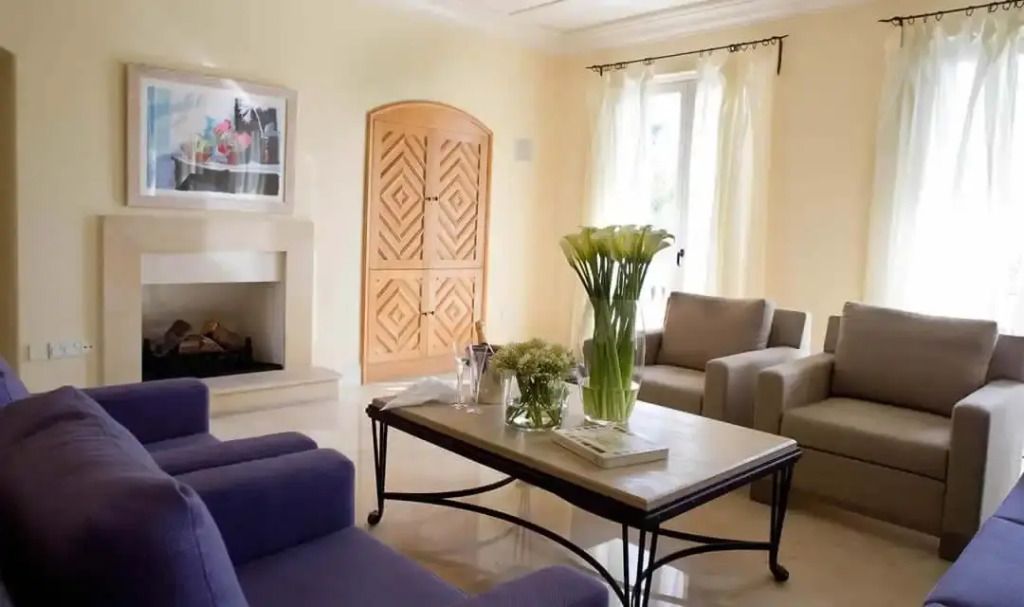 Gemütlicher Wohnbereich mit floralem Akzent und Kamin in der Alexandros Residence