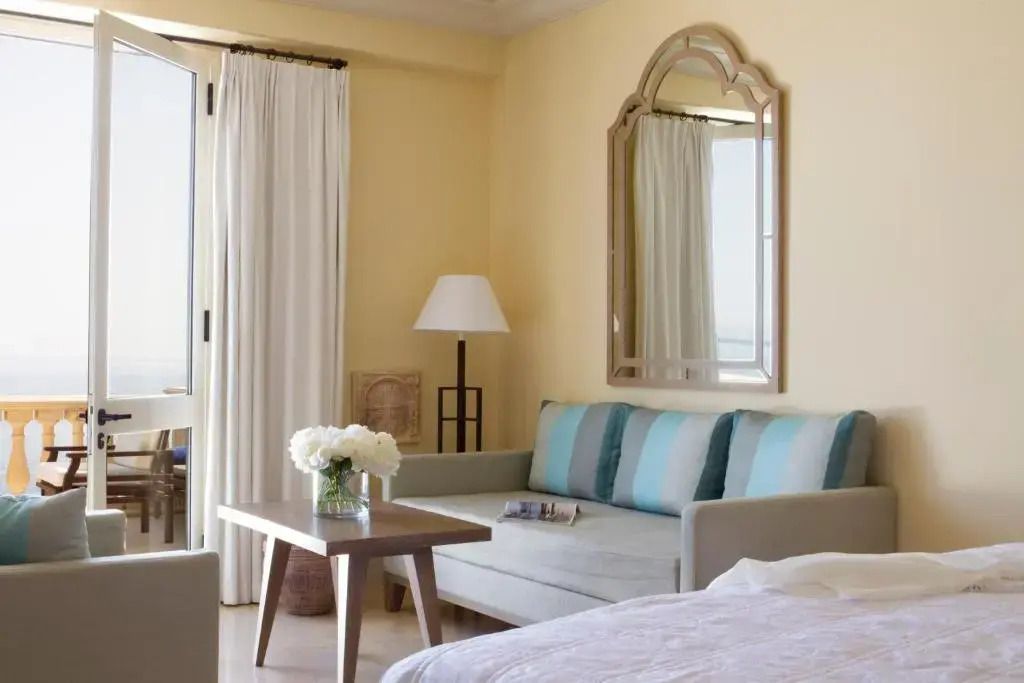 Gemütliche Sitzecke mit großem Spiegel und eleganter Dekoration im Anax Suite.