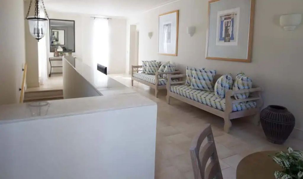 Helles Wohnzimmer in der Andromeda Residence mit modernen Sofas und Kunstwerken an der Wand