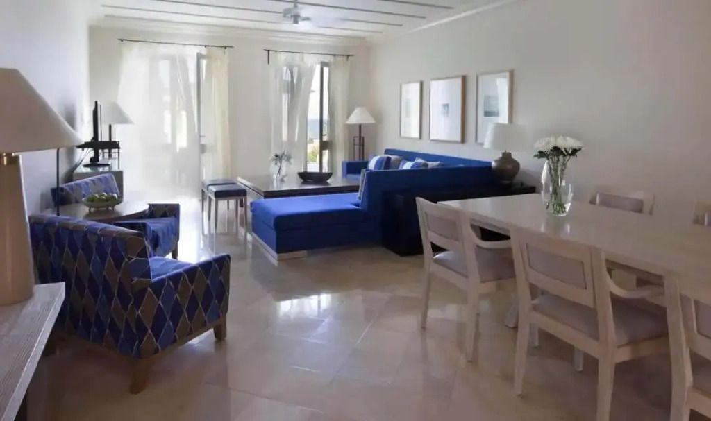 Stilvoll eingerichtetes Wohnzimmer mit blauer Couch und Essbereich