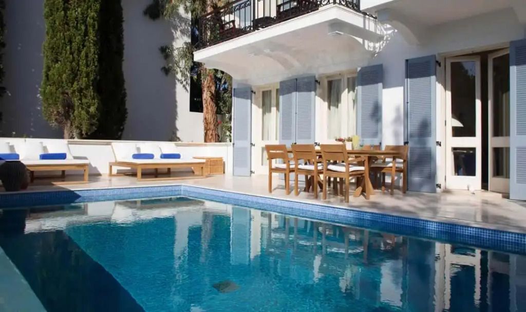 Privater Poolbereich mit Sonnenliegen und Holzmöbeln auf der Terrasse