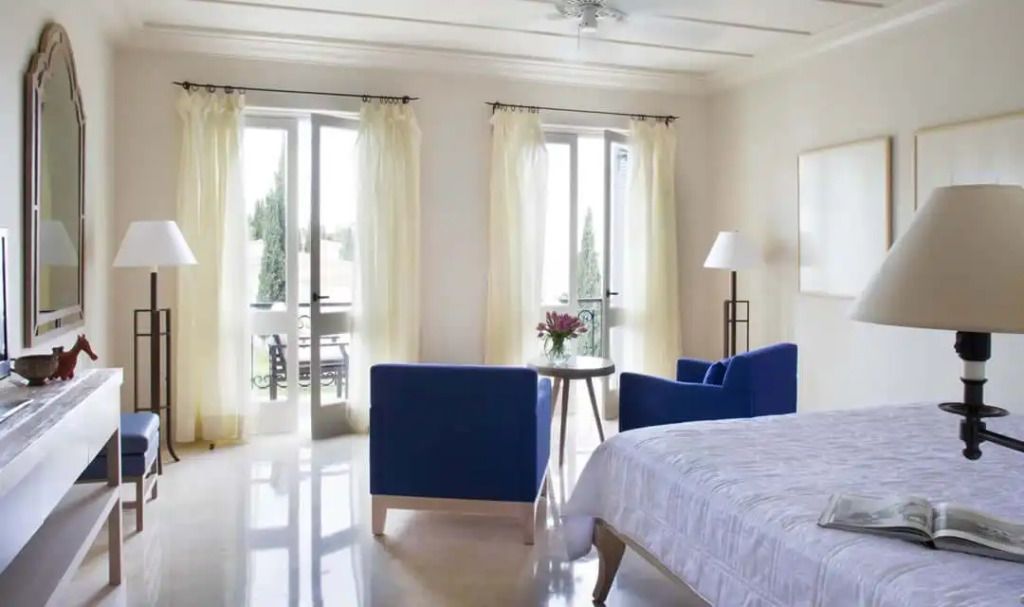 Großzügiges Schlafzimmer mit Sitzgelegenheit und Blick auf den Balkon