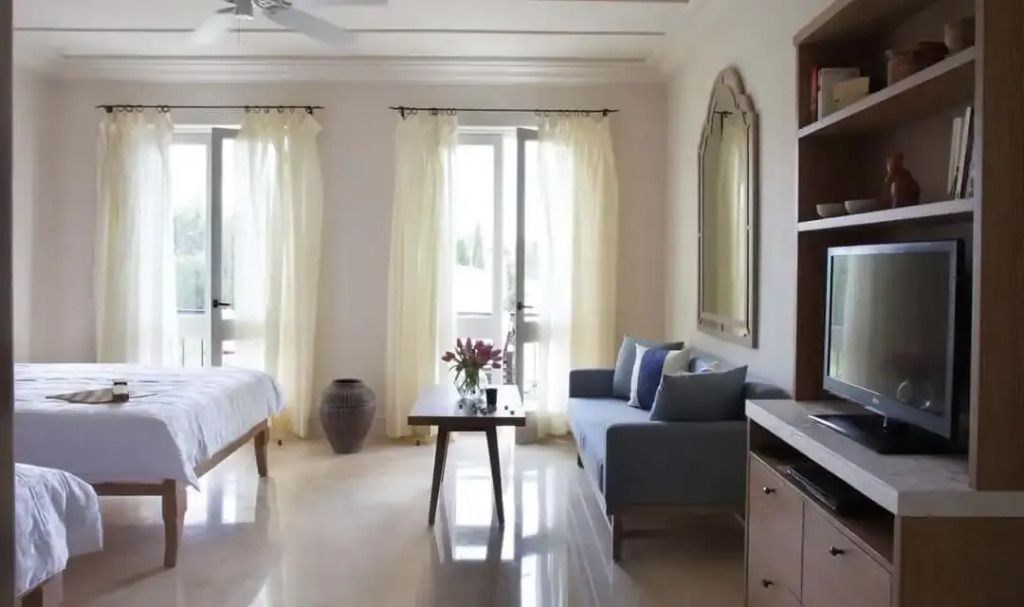 Helles Schlafzimmer mit Balkonzugang und gemütlicher Sitzecke