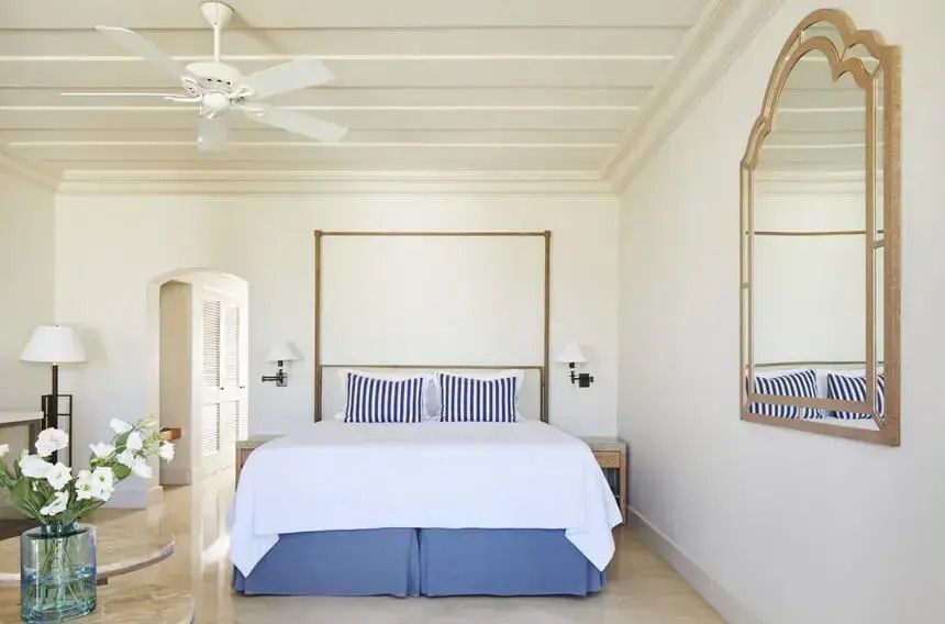 Helles Doppelzimmer mit blauen Akzenten und Deckenventilator