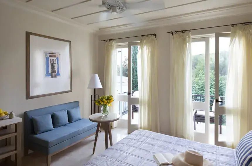 Helles Doppelzimmer mit Balkon, großer Fensterfront und gemütlicher Sitzecke