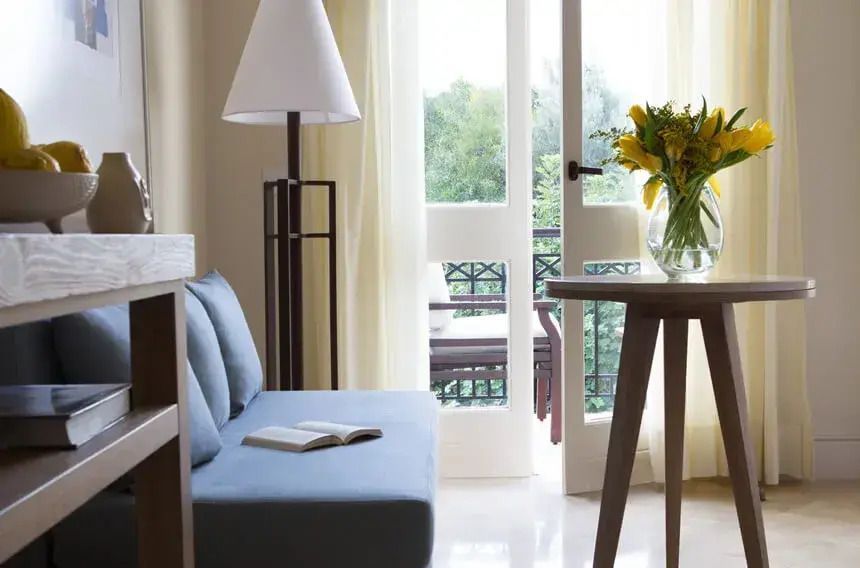 Sitzecke mit blauer Couch und Tisch im Doppelzimmer mit Zugang zum Balkon