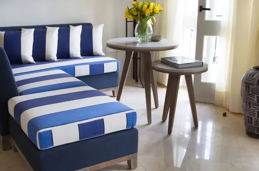 Gemütliche Sitzecke mit blau-weiß gestreiftem Sofa und frischem Blumenstrauß.