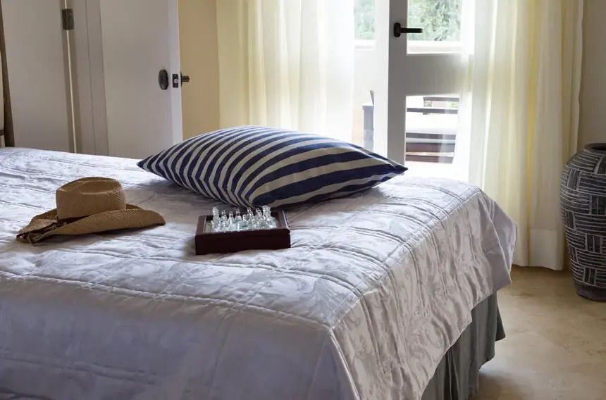 Gemütliches Bett mit gestreiften Details und hellem Tageslicht