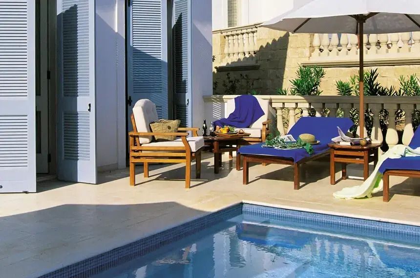 Private Terrasse mit Pool und bequemen Liegestühlen bei schönem Wetter