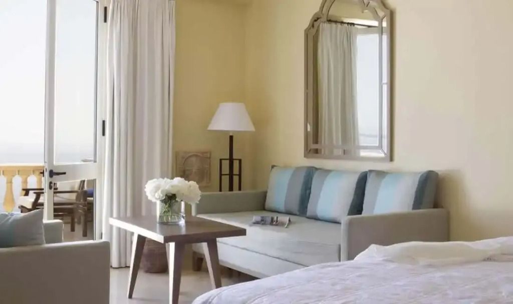 Gemütlicher Sitzbereich mit Sofa und Spiegel in modernem Suite-Design