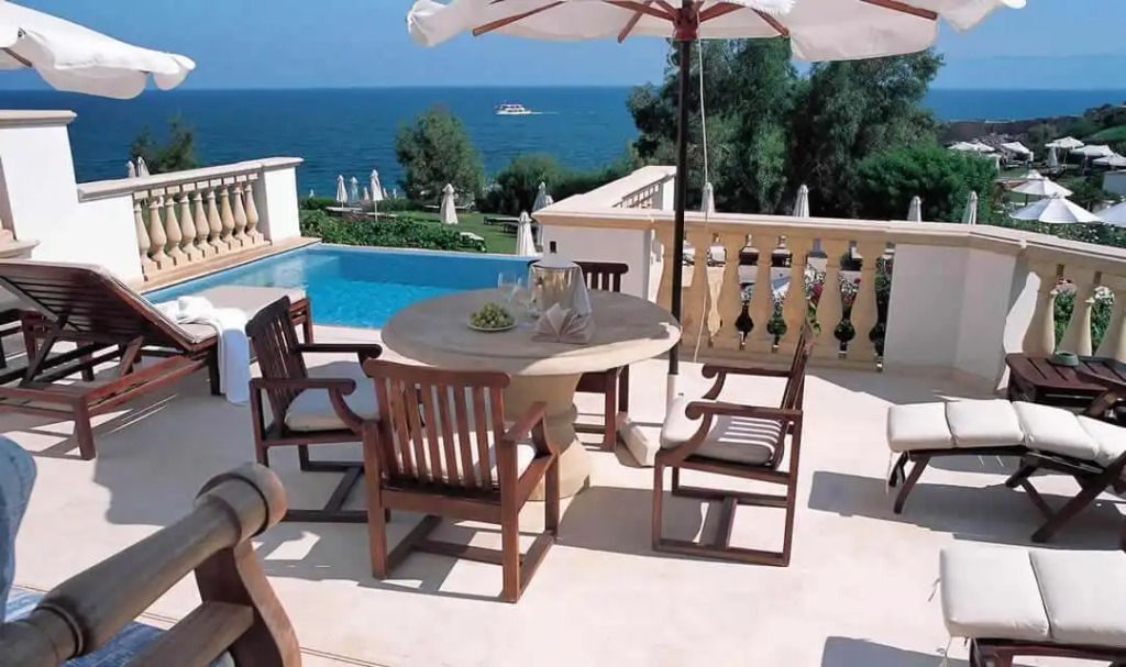 Terrasse mit Meerblick-Sitzbereich und Sonnenschirm neben privatem Pool
