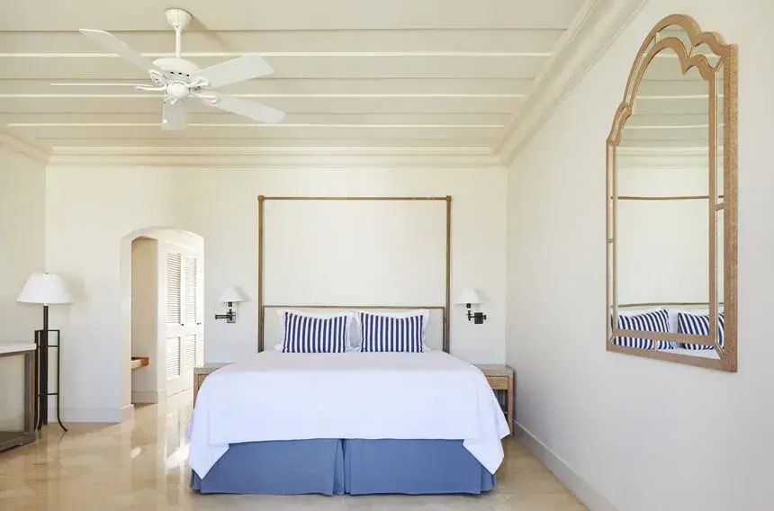 Helles Schlafzimmer mit Doppelbett und Deckenventilator in der Suite