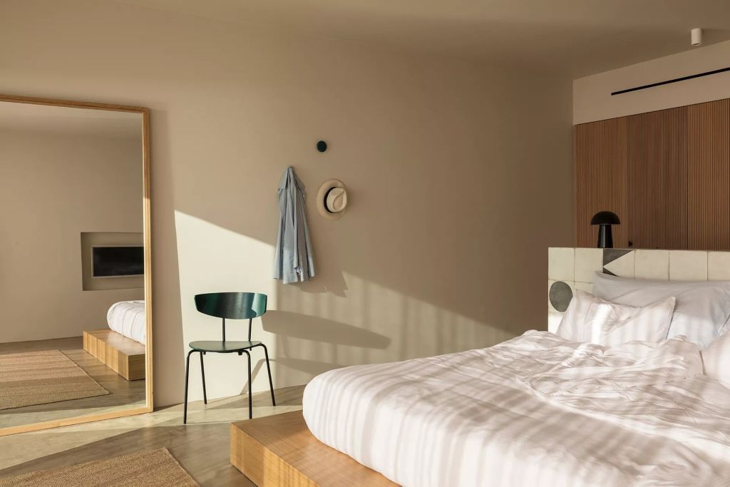 Elegantes Zimmer mit Spiegel, Stuhl und Hut an der Wand