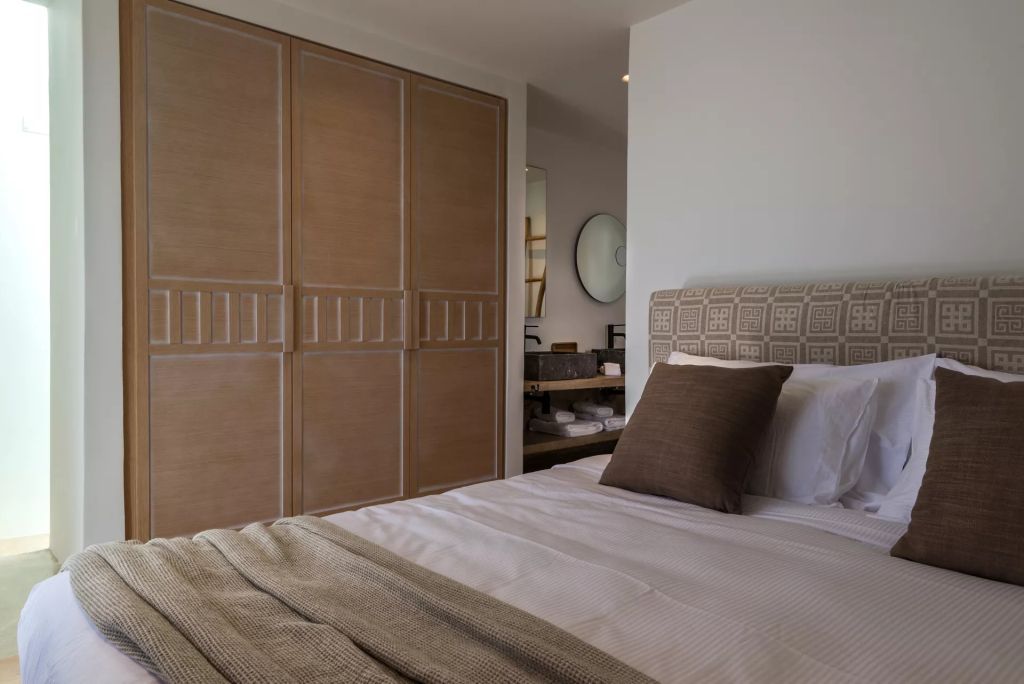 Helles Schlafzimmer mit großem Kleiderschrank und Bett