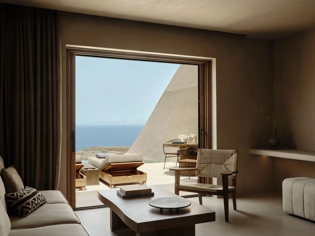 Stilvolles Wohnzimmer mit offener Tür zur Terrasse und Blick auf das Meer