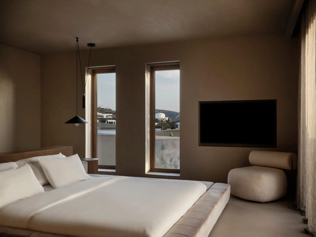 Modernes Schlafzimmer der Oasis Suite mit minimalistischer Einrichtung und Fensterfront.