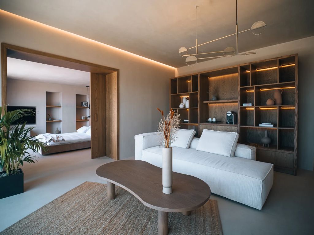 Wohnbereich in der Oasis Suite mit bequemer Couch und eleganten Holzmöbeln.