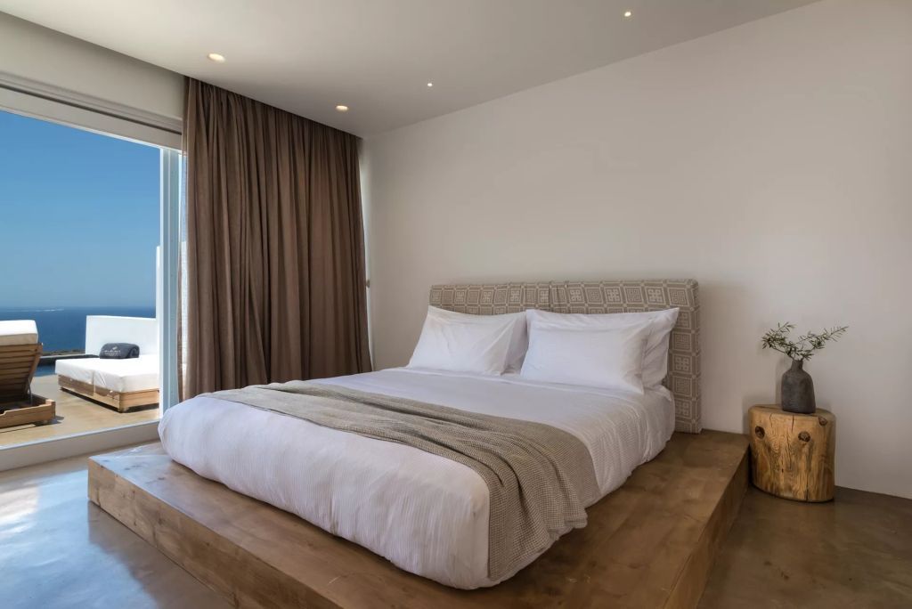 Modernes Schlafzimmer mit Doppelbett in neutralen Tönen und großen Vorhängen