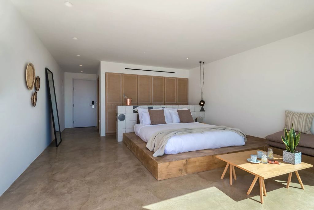 Geräumiges Schlafzimmer mit Kingsize-Bett und heller, minimalistischer Einrichtung in der Sunset Suite