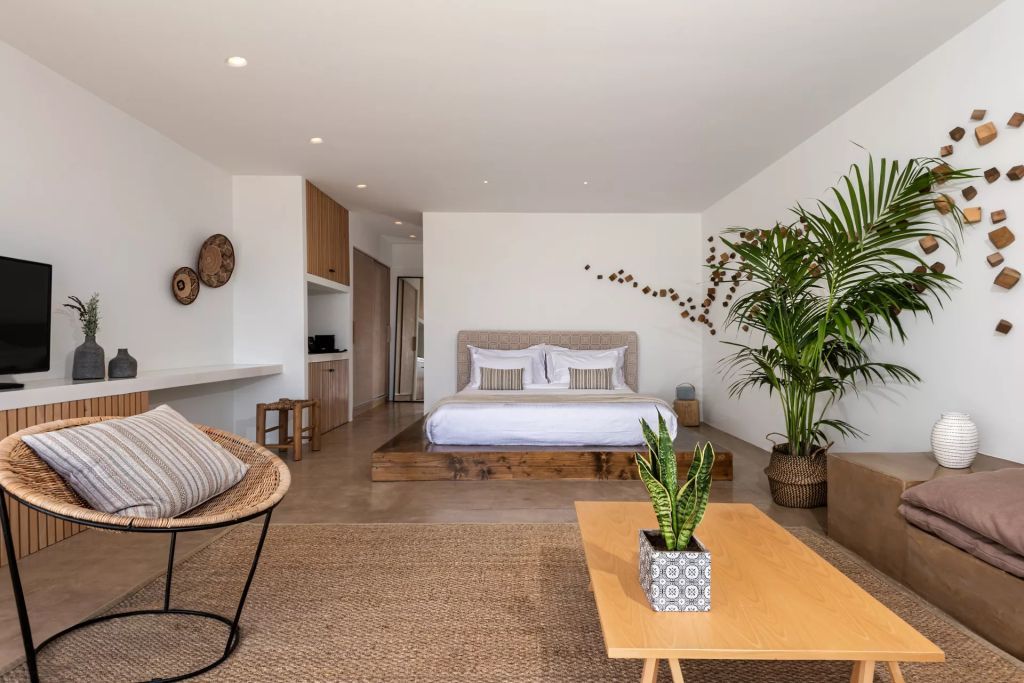 Suite mit Holz- und Pflanzenakzenten und einem großen Bett in entspannendem Ambiente