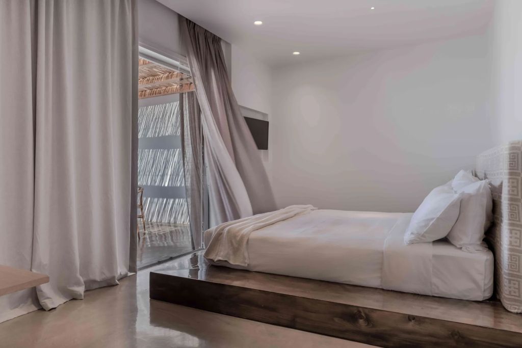 Elegantes Schlafzimmer mit offenem Vorhang und Balkonblick