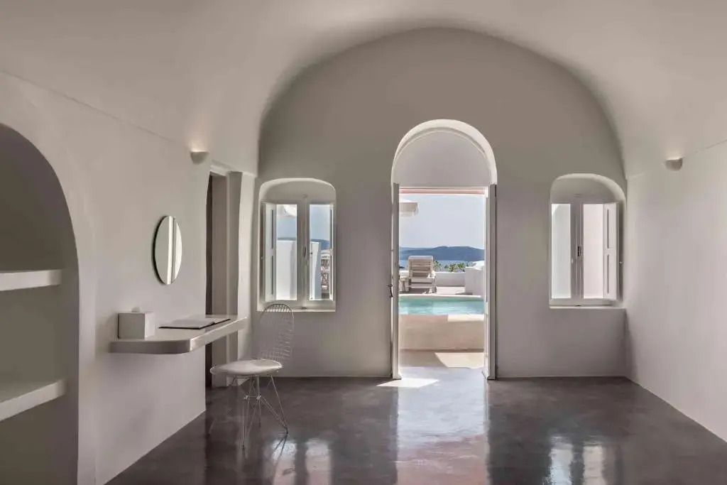 Heller Raum mit Bögen, offenem Blick zum Pool und elegantem minimalistischen Stil.
