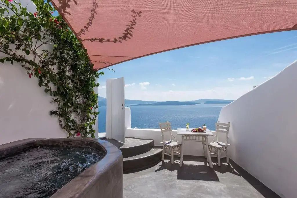 Terrasse mit Whirlpool und Meerblick unter Sonnensegel mit Pflanzen