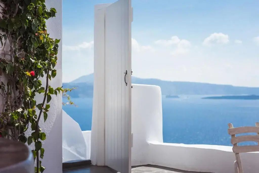 Offene Tür mit Blick auf das blaue Meer und entfernte Inseln