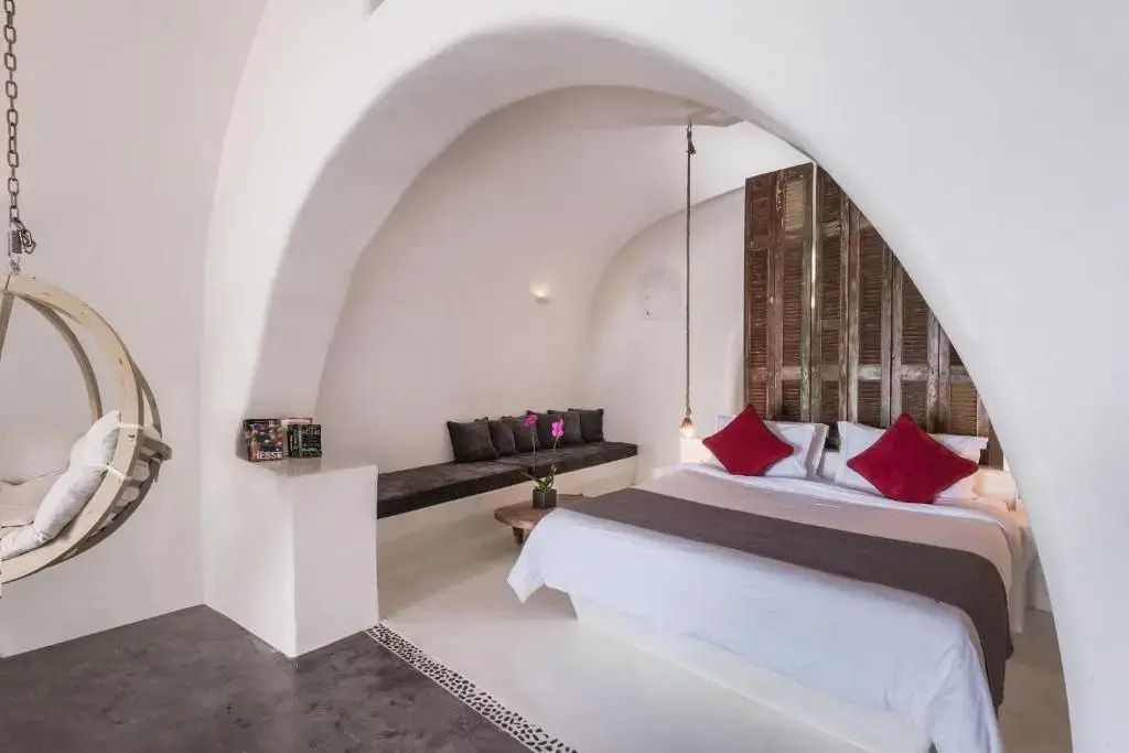 Elegantes Hotelzimmer mit modernem Design und Doppelbett unter einem Bogen.