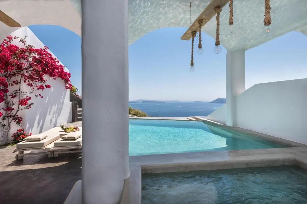 Infinity Pool mit atemberaubender Aussicht auf das Meer und blühenden Bougainvillea.