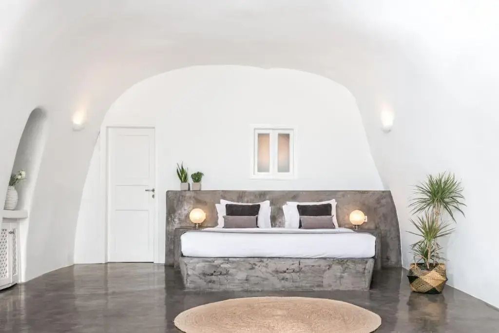 Elegantes Doppelbett in Höhlenarchitektur mit minimalistischem Design und hellen Tönen.